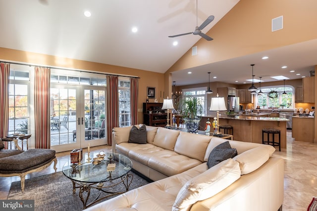 living area with plenty of natural light, a ceiling fan, visible vents, and french doors