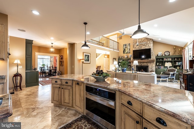 kitchen with oven, decorative light fixtures, lofted ceiling, light stone counters, and a stone fireplace