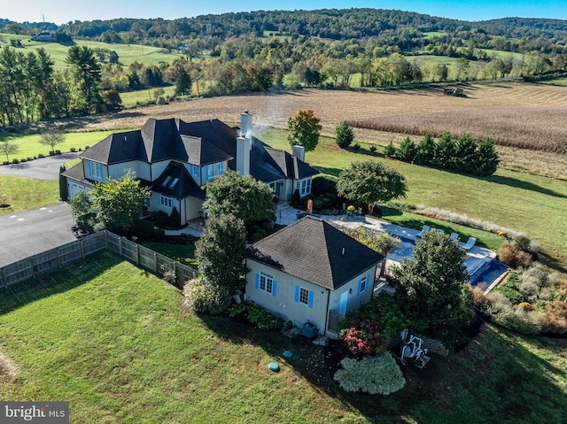 drone / aerial view featuring a rural view and a view of trees