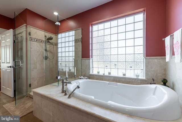 full bath featuring a garden tub and a shower stall