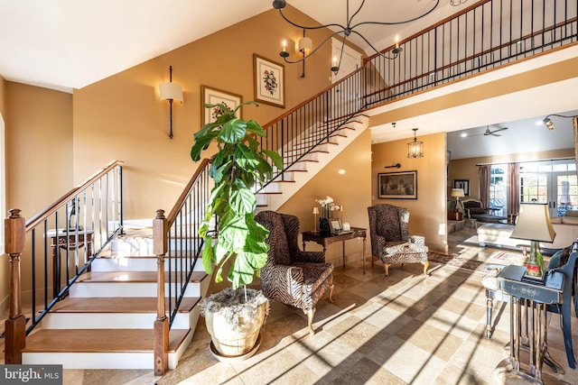 staircase featuring a high ceiling and a chandelier