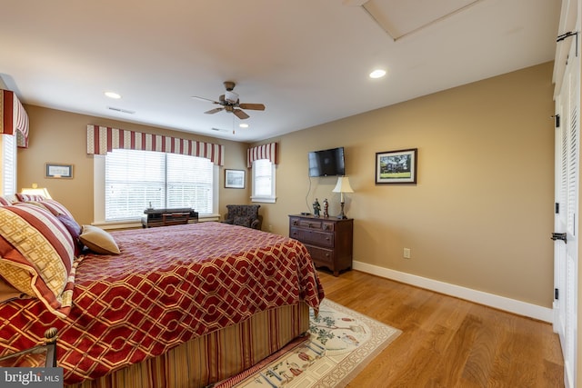 bedroom featuring light wood finished floors, visible vents, baseboards, recessed lighting, and a ceiling fan