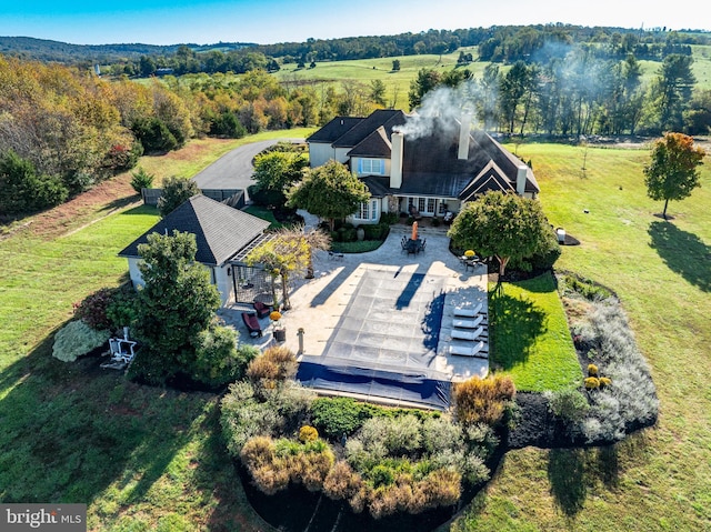 drone / aerial view featuring a wooded view