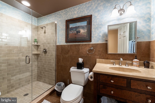 full bathroom featuring a wainscoted wall, toilet, a stall shower, and wallpapered walls