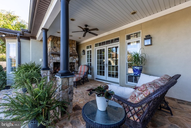 view of patio / terrace with a ceiling fan, french doors, and an outdoor stone fireplace