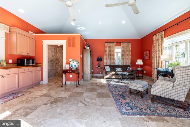 living room with baseboards, visible vents, a ceiling fan, and lofted ceiling