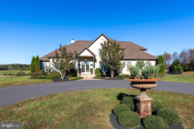 view of front facade with french doors and a front lawn