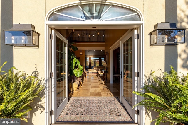 view of exterior entry with stucco siding and french doors