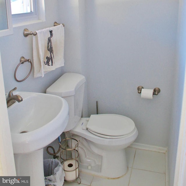 bathroom featuring toilet, sink, and tile patterned flooring