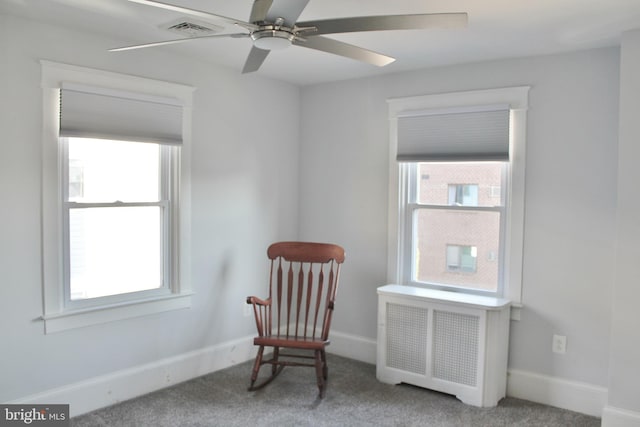 sitting room featuring radiator, ceiling fan, and carpet flooring