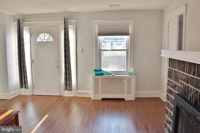 entrance foyer with hardwood / wood-style flooring and radiator heating unit