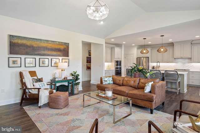 living room with dark wood-type flooring, lofted ceiling, and sink