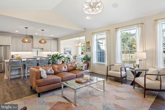 living room with sink, a notable chandelier, lofted ceiling, and dark hardwood / wood-style flooring