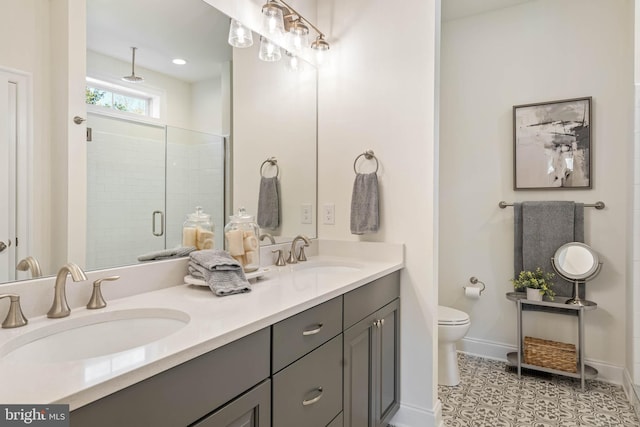 bathroom featuring a shower with door, vanity, and toilet