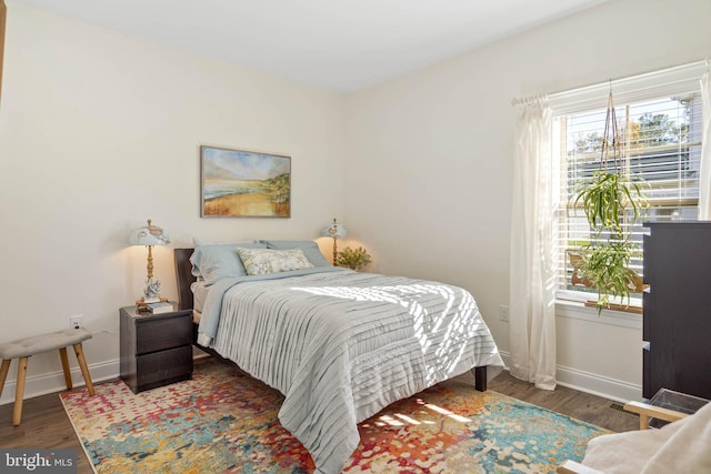 bedroom with dark hardwood / wood-style flooring