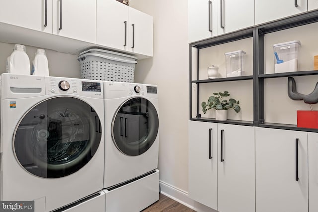 clothes washing area featuring cabinets, dark hardwood / wood-style floors, and washing machine and dryer