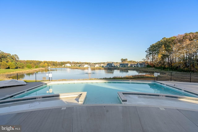 view of swimming pool with a patio and a water view