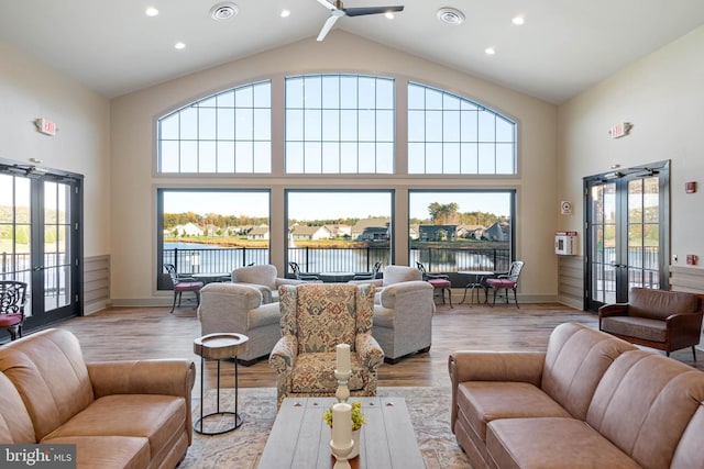 living room featuring french doors, a water view, and plenty of natural light