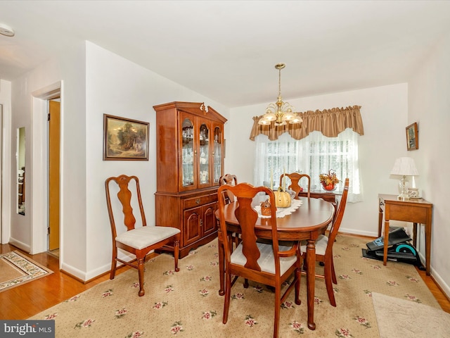 dining area with an inviting chandelier and light hardwood / wood-style floors