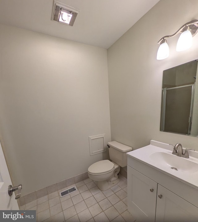 bathroom with tile patterned flooring, vanity, toilet, and walk in shower