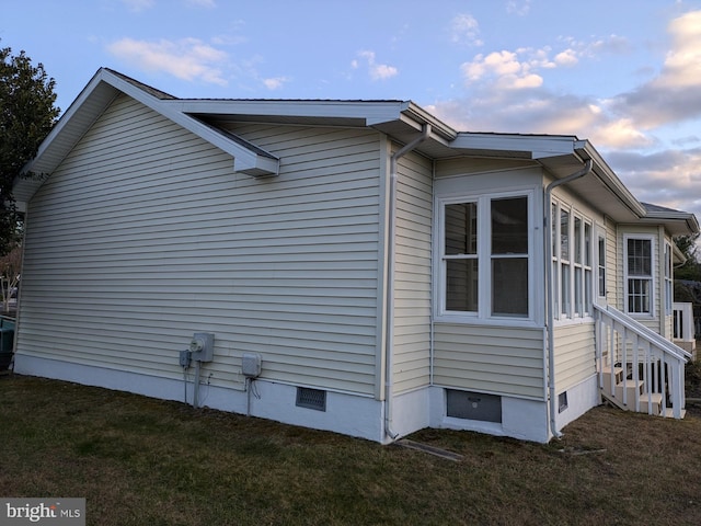 property exterior at dusk with a lawn