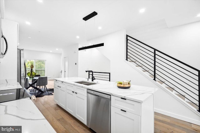 kitchen featuring light stone countertops, stainless steel appliances, sink, hardwood / wood-style flooring, and white cabinets