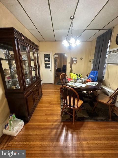 dining room with a paneled ceiling, a notable chandelier, and light hardwood / wood-style flooring