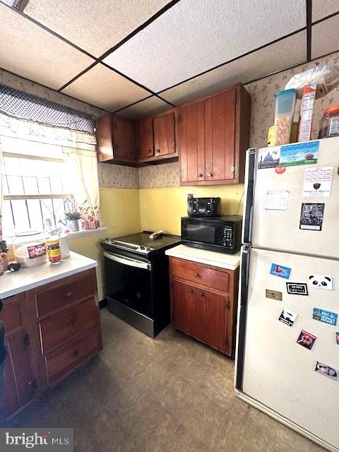 kitchen featuring a paneled ceiling and black appliances