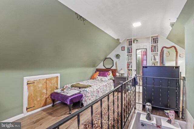 bedroom featuring hardwood / wood-style flooring and lofted ceiling