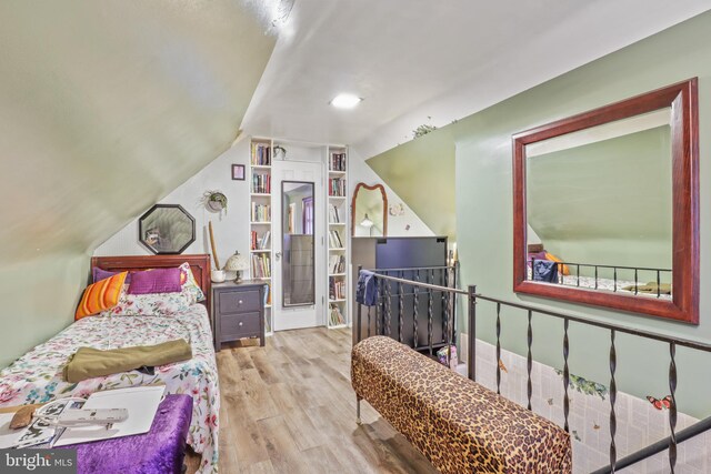 bedroom with lofted ceiling and light wood-type flooring