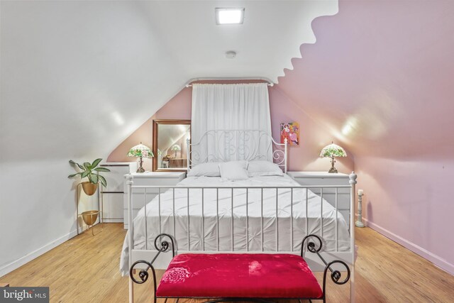 bedroom featuring vaulted ceiling and light wood-type flooring