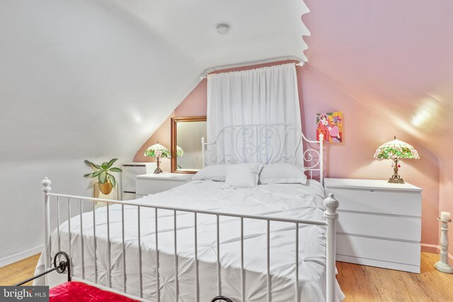 bedroom featuring light hardwood / wood-style flooring and lofted ceiling