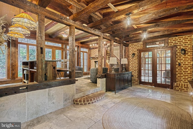 misc room with french doors, beamed ceiling, brick wall, and ceiling fan