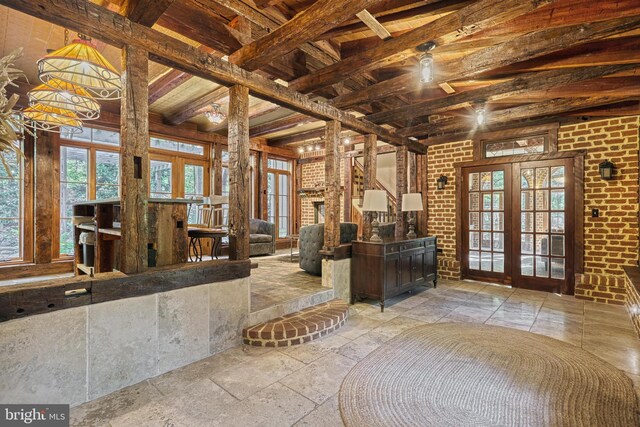 995 Black Gap Rd, Fayetteville, PA 17222 - interior space featuring stone tile flooring, beamed ceiling, french doors, and brick wall