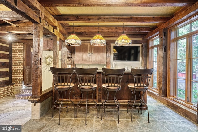 bar with beamed ceiling, hanging light fixtures, and wood ceiling