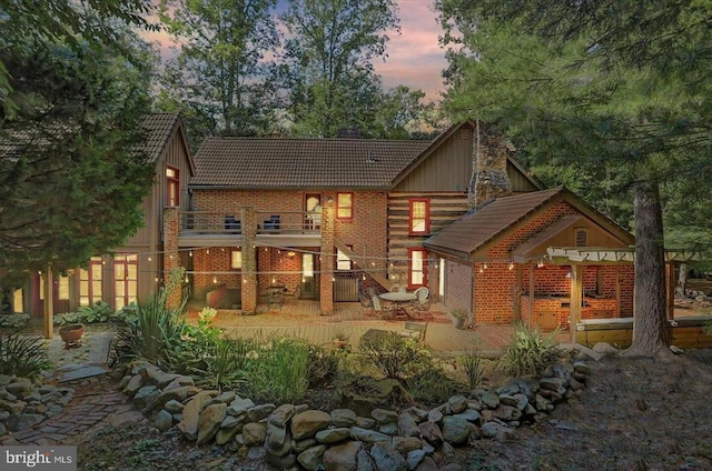 back house at dusk with a balcony