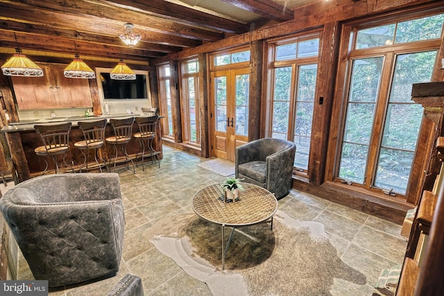 living room with beam ceiling and french doors