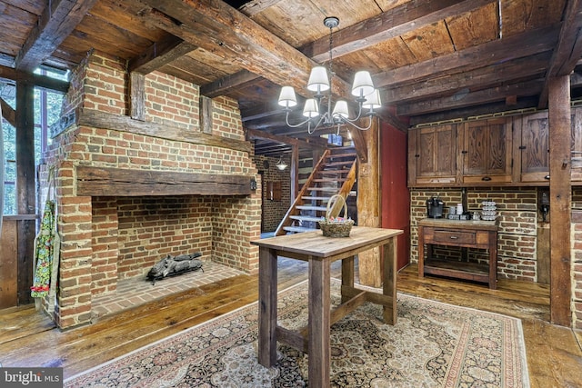 dining area with an inviting chandelier, hardwood / wood-style flooring, wooden ceiling, beamed ceiling, and brick wall