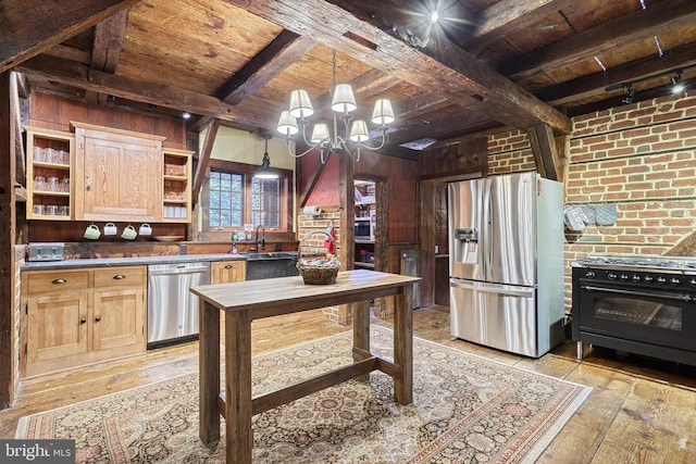 kitchen with beam ceiling, hanging light fixtures, appliances with stainless steel finishes, wooden ceiling, and wood walls