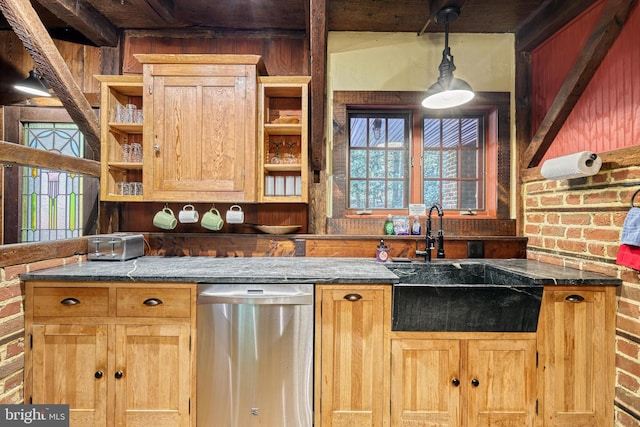 kitchen featuring dishwasher, dark stone counters, brick wall, sink, and pendant lighting