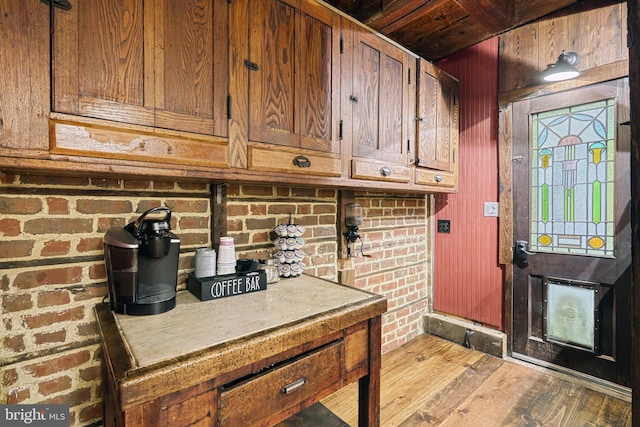 interior space featuring brick wall and hardwood / wood-style floors