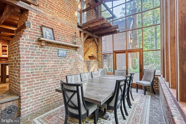 995 Black Gap Rd, Fayetteville, PA 17222 - dining area with stone tile flooring, a high ceiling, and brick wall