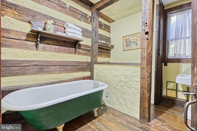 bathroom featuring hardwood / wood-style flooring and a bath