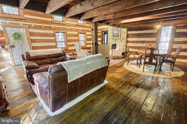 living room featuring beam ceiling, a stone fireplace, and dark hardwood / wood-style floors