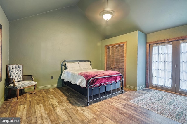 bedroom with a closet, hardwood / wood-style floors, ceiling fan, and vaulted ceiling