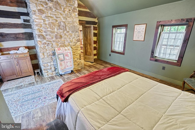 bedroom featuring lofted ceiling and light wood-type flooring