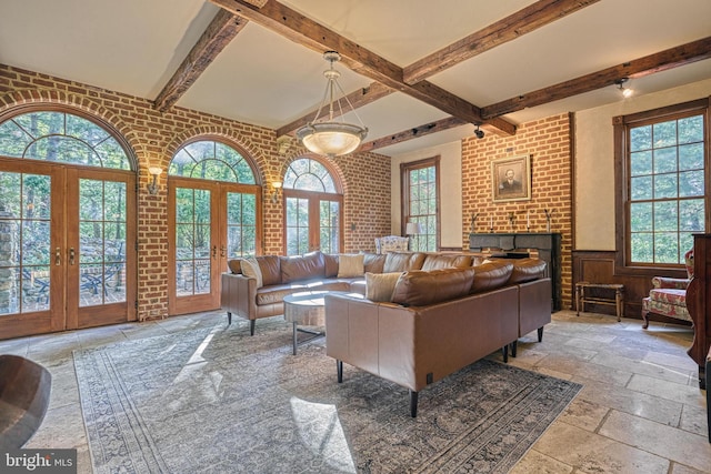 living room featuring brick wall, french doors, and plenty of natural light