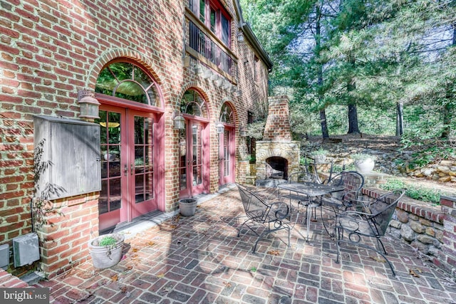 view of patio featuring french doors and a fireplace