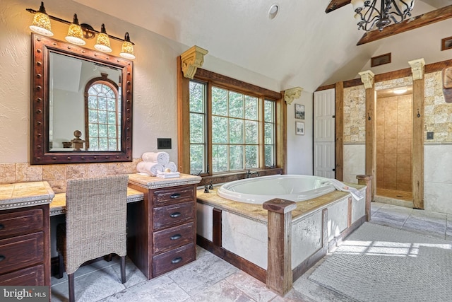 bathroom featuring vanity, lofted ceiling, a wealth of natural light, and shower with separate bathtub