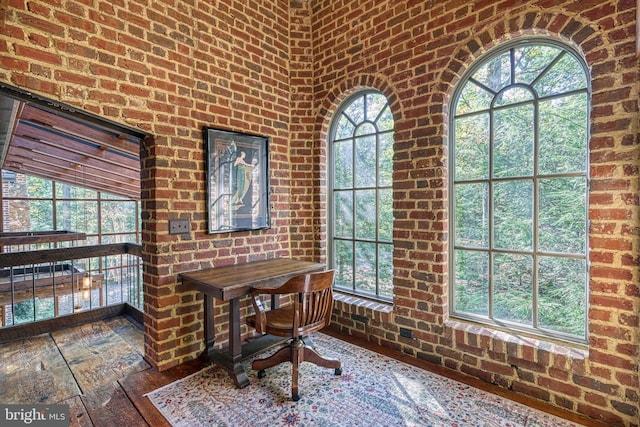 office area featuring brick wall and dark hardwood / wood-style flooring